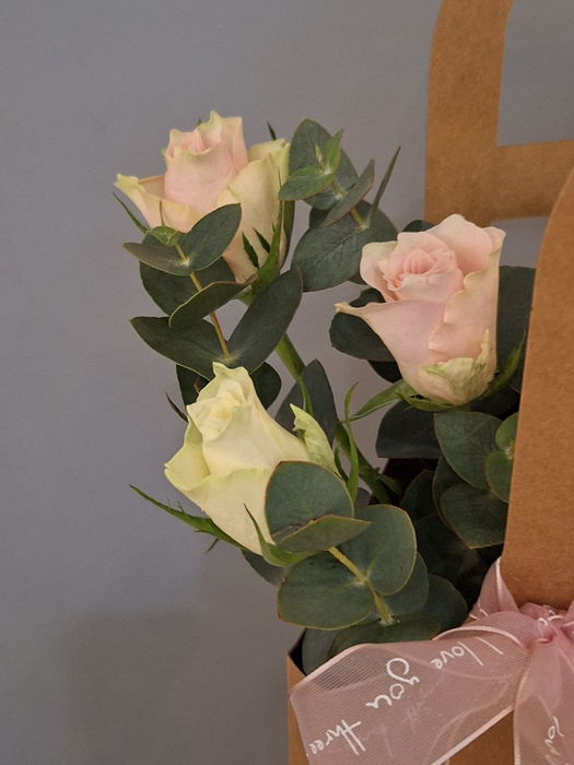 Нежная композиция из роз с эвкалиптом в сумочке