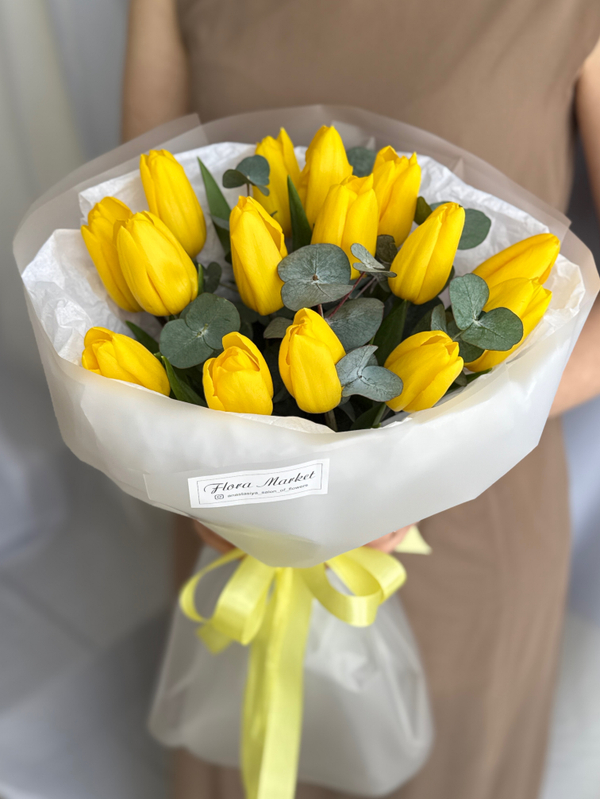 Яркие желтые тюльпаны премиум сорта и зелень эвкалипта в воздушном оформлении от Флора Маркет