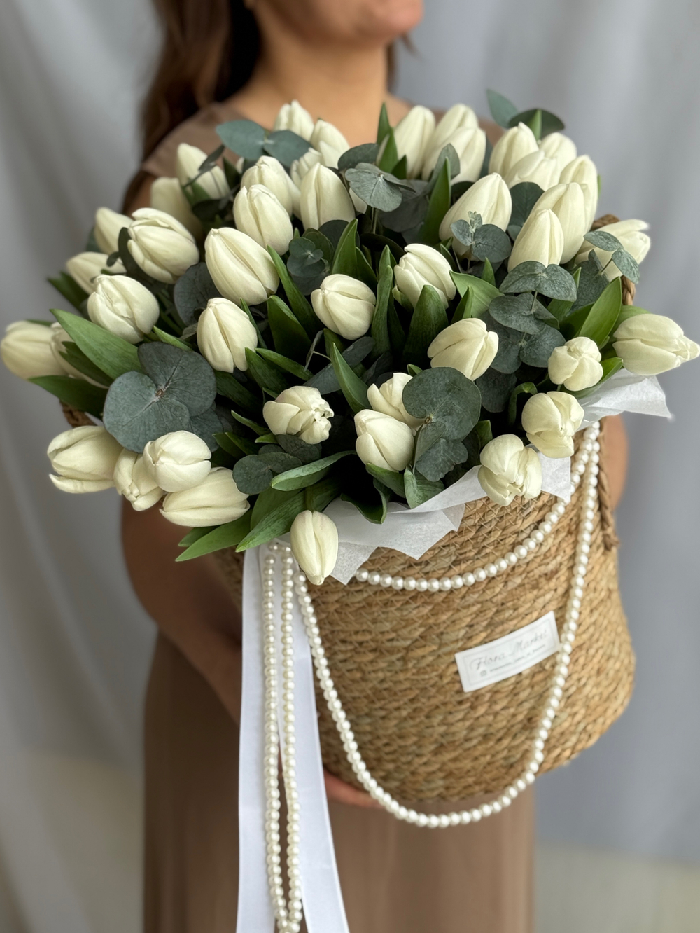 Охапка белых тюльпанов и благородный эвкалипт в стильной корзине от Флора Маркет