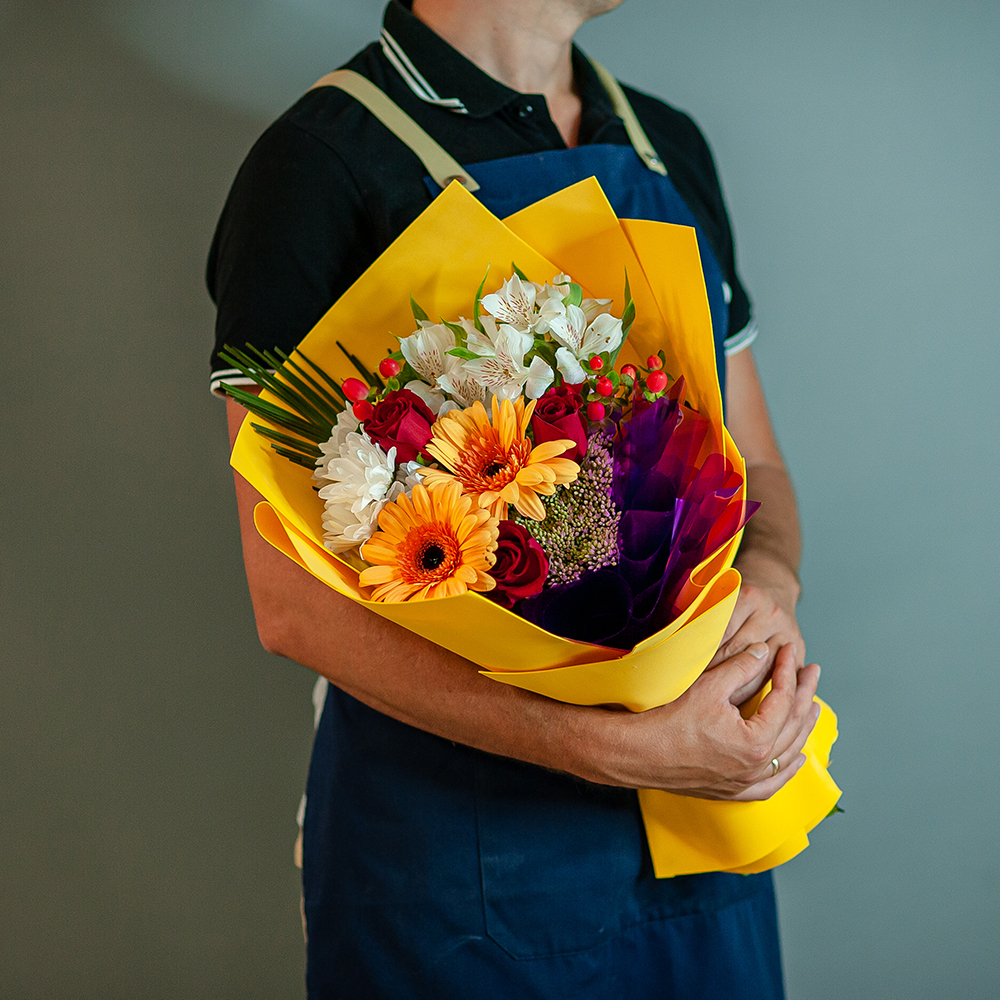 Яркий букет в желтой цветовой гамме с герберами и красными розами
