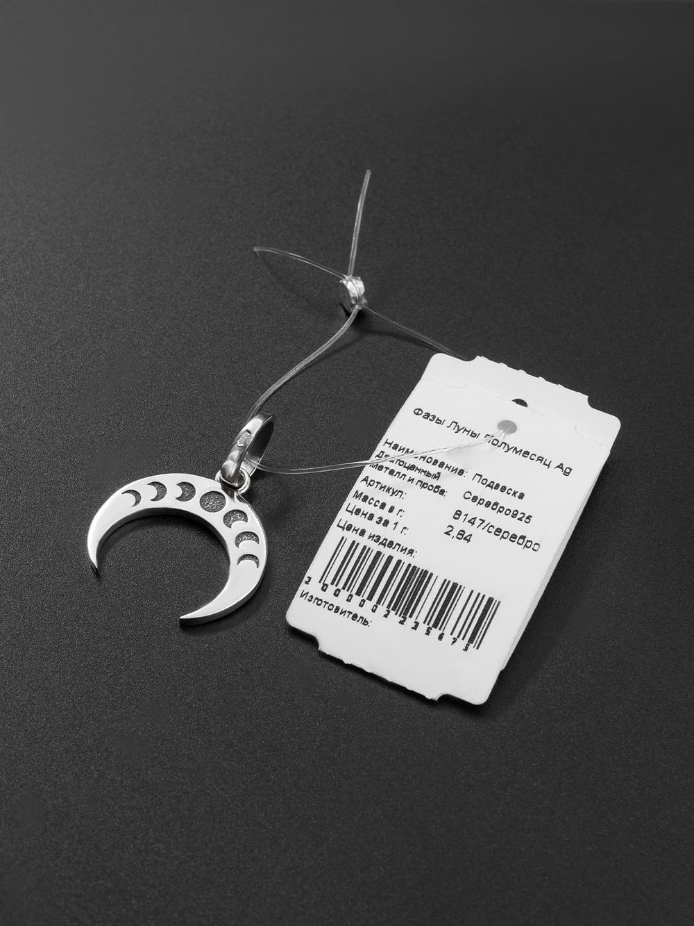 Фотография ювелирного украшения лунница с ювелирной биркой.