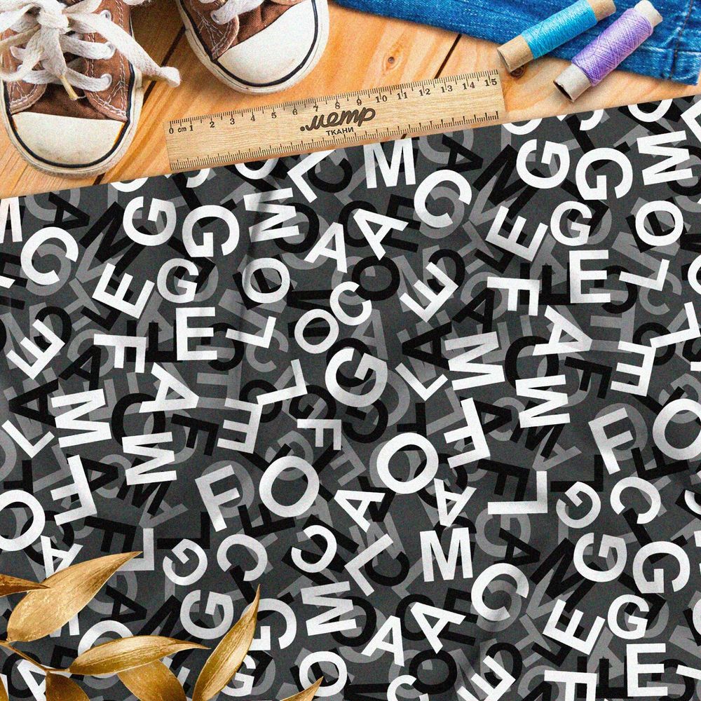 Ткань барби хаос их букв на чёрном фоне