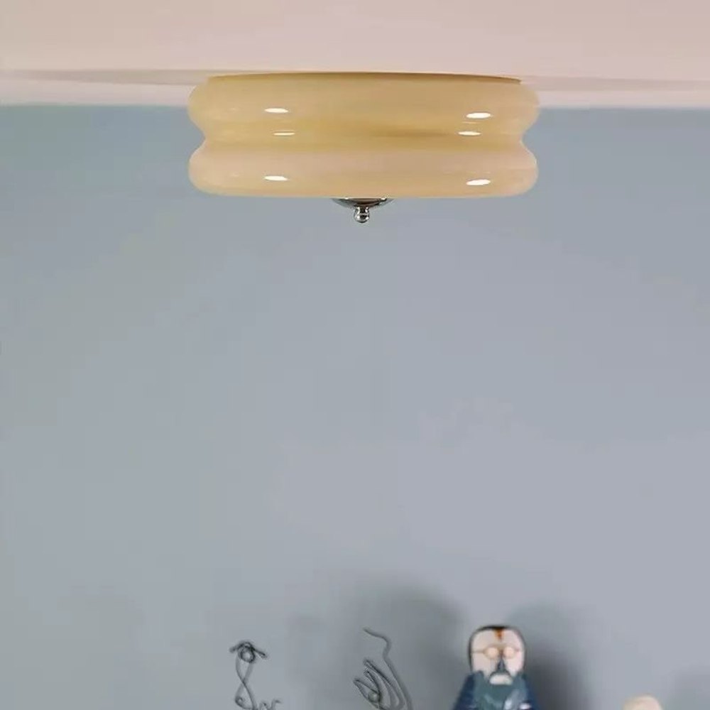 Потолочный светильник с гладким стеклянным плафоном кремового оттенка.