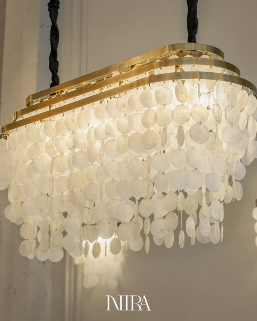 Элегантная подвесная люстра с каскадом перламутровых пластин, которые мягко рассеивают свет и создают уютное, тёплое свечение.