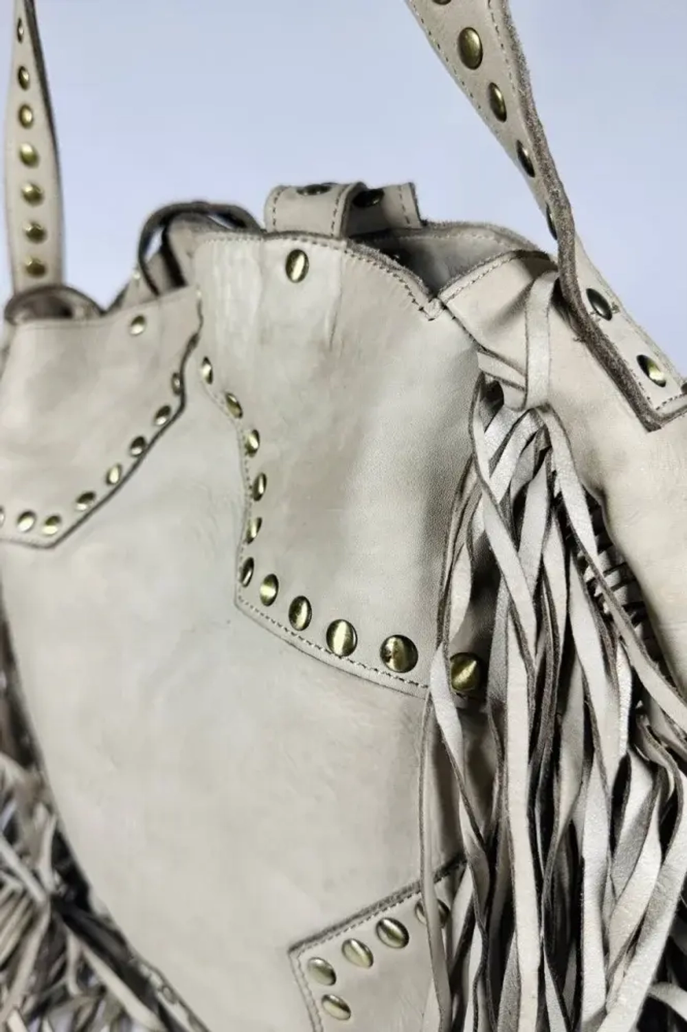 Женская сумка из натуральной вареной кожи с бахромой и заклепками цвет слоновая кость