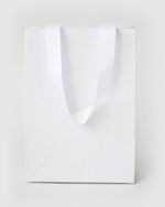 Подарочный пакет с репсовой лентой из дизайнерской бумаги.