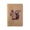 Обложка для паспорта с лазерной гравировкой Белка с орехом из светло-коричневого нубука на белом фоне в сложенном виде.