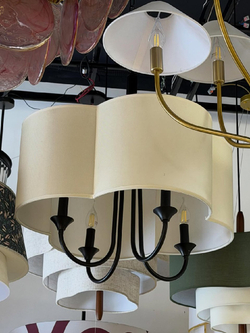 Элегантная люстра с текстильным абажуром в светлом оттенке и черным металлическим основанием.