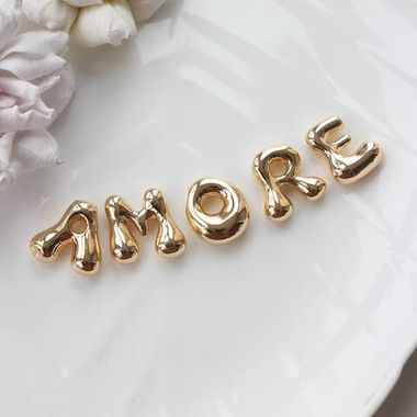 Слово из букв AMORE в золоте