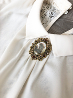 Брошь камея в бронзовой рамке из цветов с кристаллами