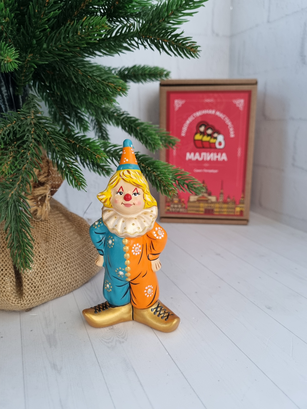 Клоун в оранжево-голубом костюме