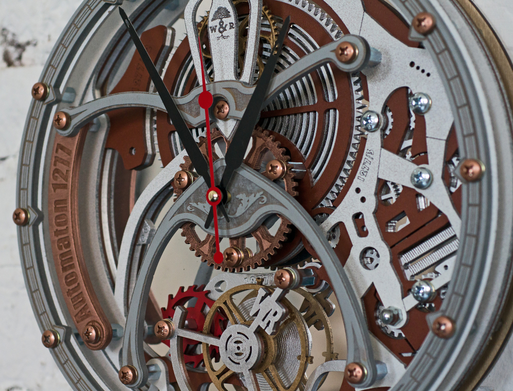 Фрагмент настенных часов WOODandROOT Automaton 1277 Tourbillon с медными элементами, стальными дугами и движением кинетических шестерёнок.