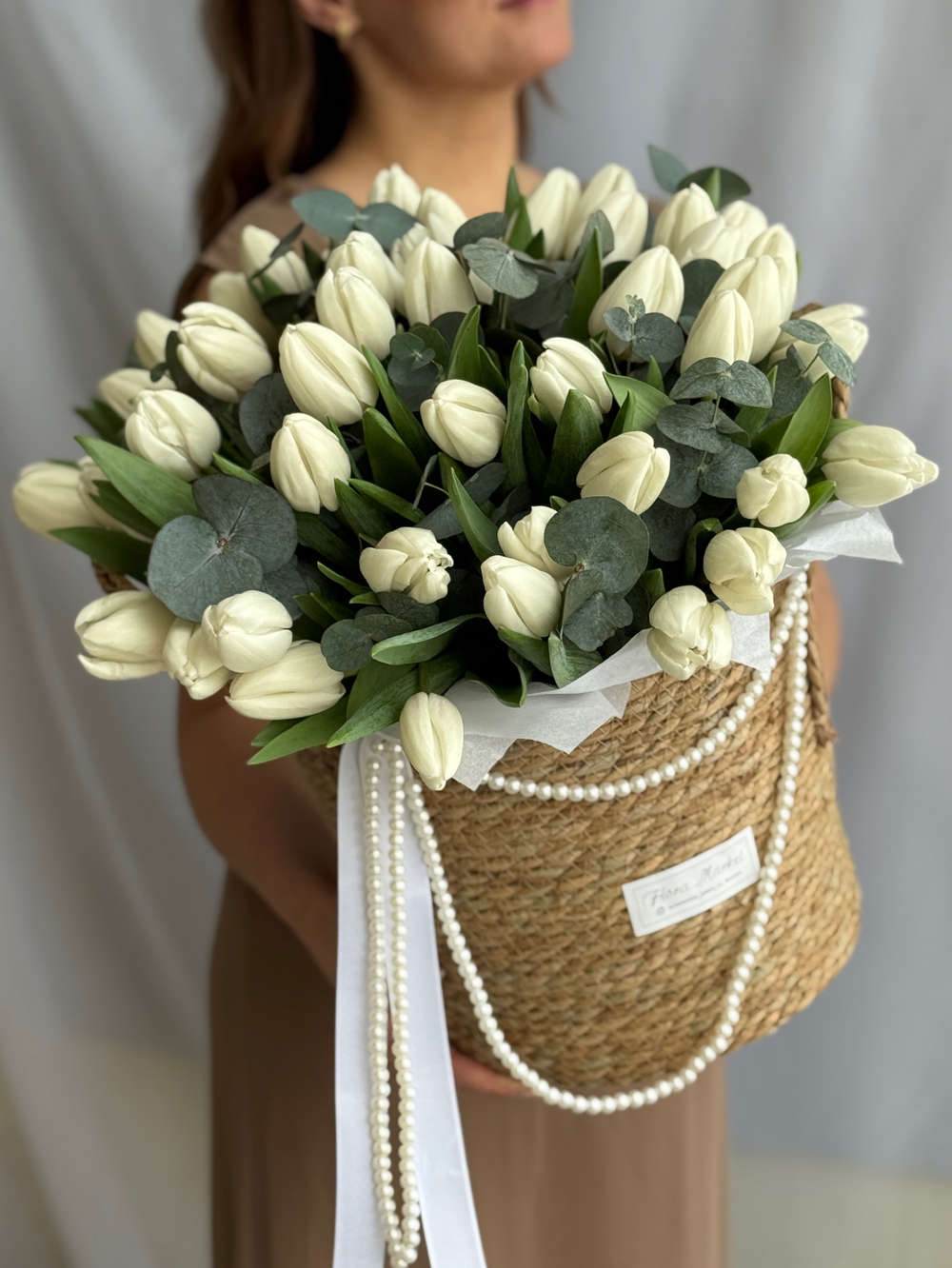 Охапка белых тюльпанов и благородный эвкалипт в стильной корзине от Флора Маркет