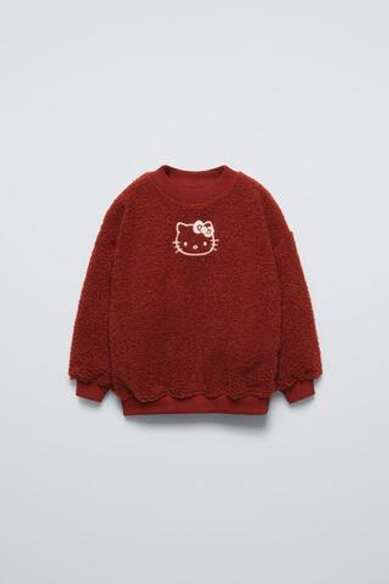 ZARA ТОЛСТОВКА ИЗ ИСКУССТВЕННОЙ ОВЧИНЫ С ПОДКЛАДКОЙ HELLO KITTY ©, КРАСНОВАТЫЙ