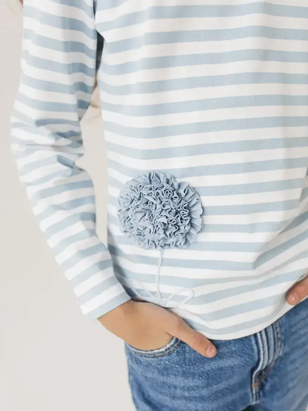 Лонгслив в бело-голубую полоску с цветком на девочке крупный план вышивки