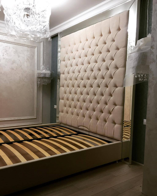 Роскошная кровать с высоким мягким изголовьем и обивкой в стиле капитоне