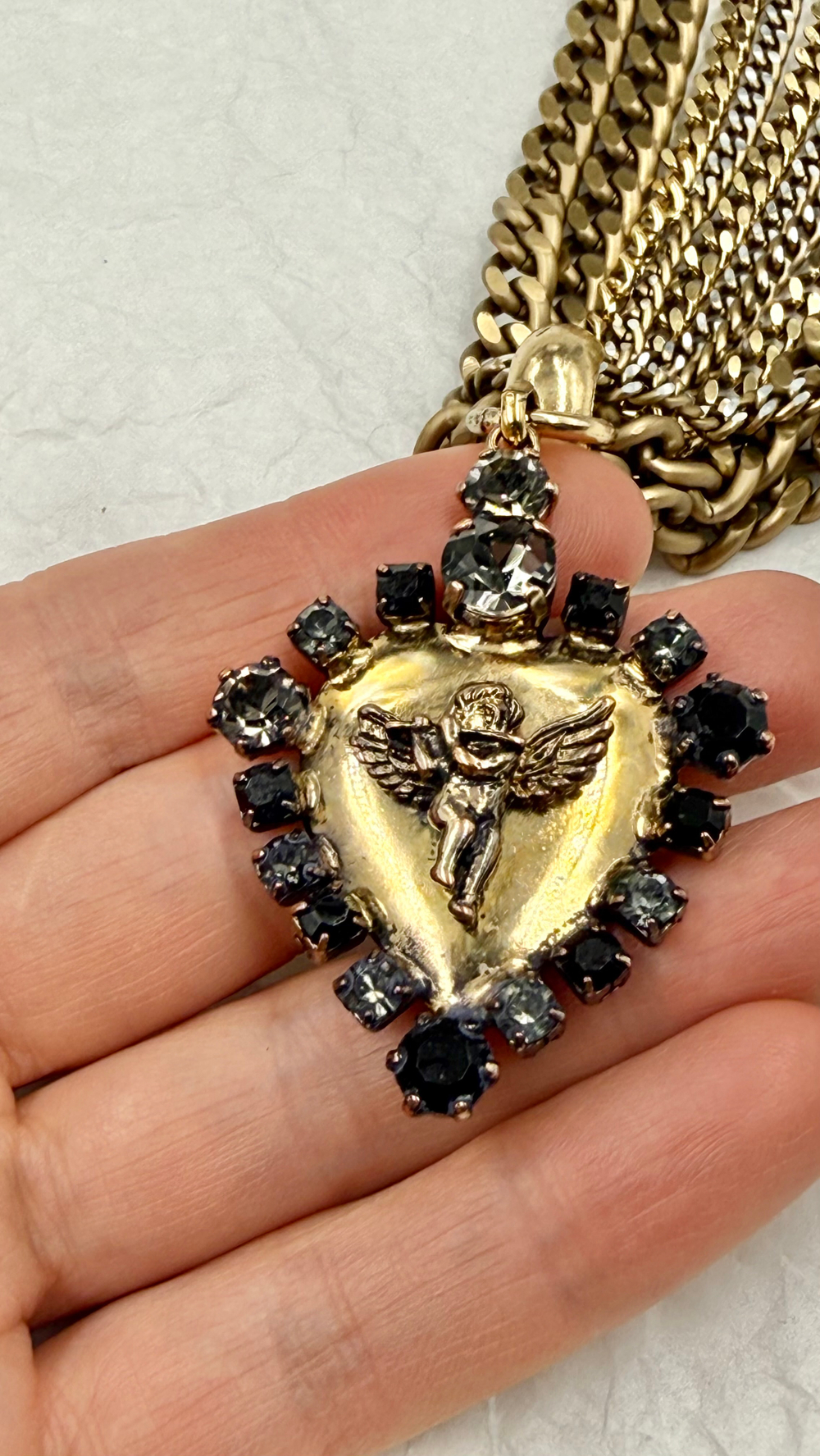 Колье кулон сердце с ангелом с флейтой, по краю черные и серые кристаллы на цепочках, золото антик