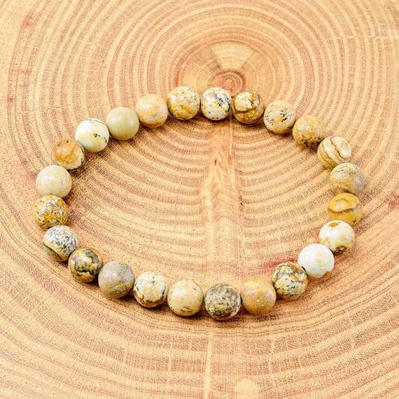 Фотография браслета из камней пейзажной яшмы фото на дереве