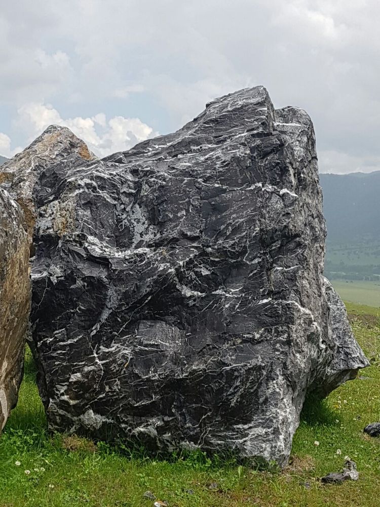 черная мраморная глыба валун, добыча с гор