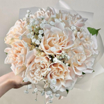 Букет невесты из 9 нежных кремовых роз и белой гипсофилы с юбочкой из матового фетра