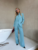 Костюм брючный в бирюзовом цвете с брошью-цветком