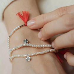 браслет из неровного белого жемчуга с красной кистью