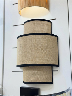 Стильное настенное бра с многоуровневым абажуром из натурального текстиля.