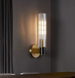 Элегантное настенное бра с вытянутым хрустальным плафоном и металлическим корпусом в тёплом золотом оттенке.