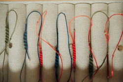 браслет «мятый лист» из желтого золота на красной нити