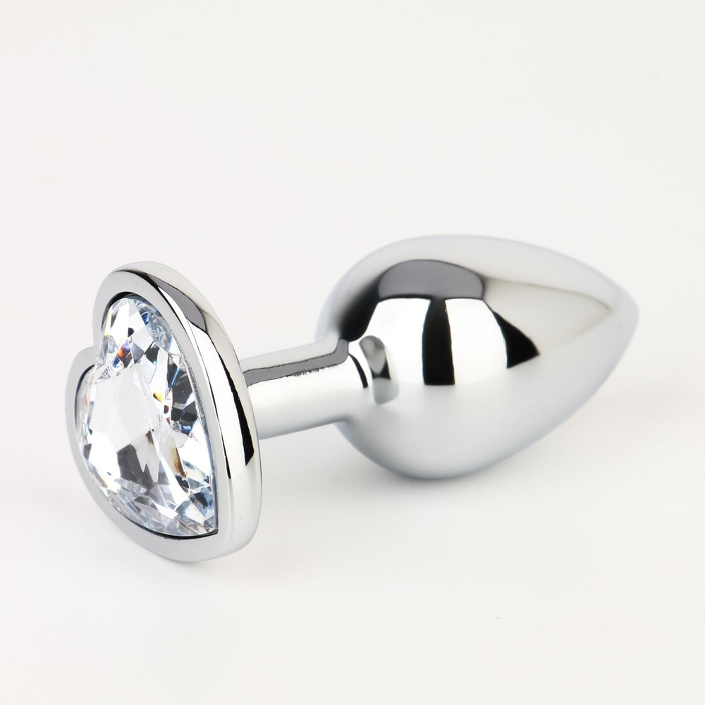 Серебристая анальная пробка с прозрачным кристаллом в форме сердца - 7 см. (Цвет: серебристый)