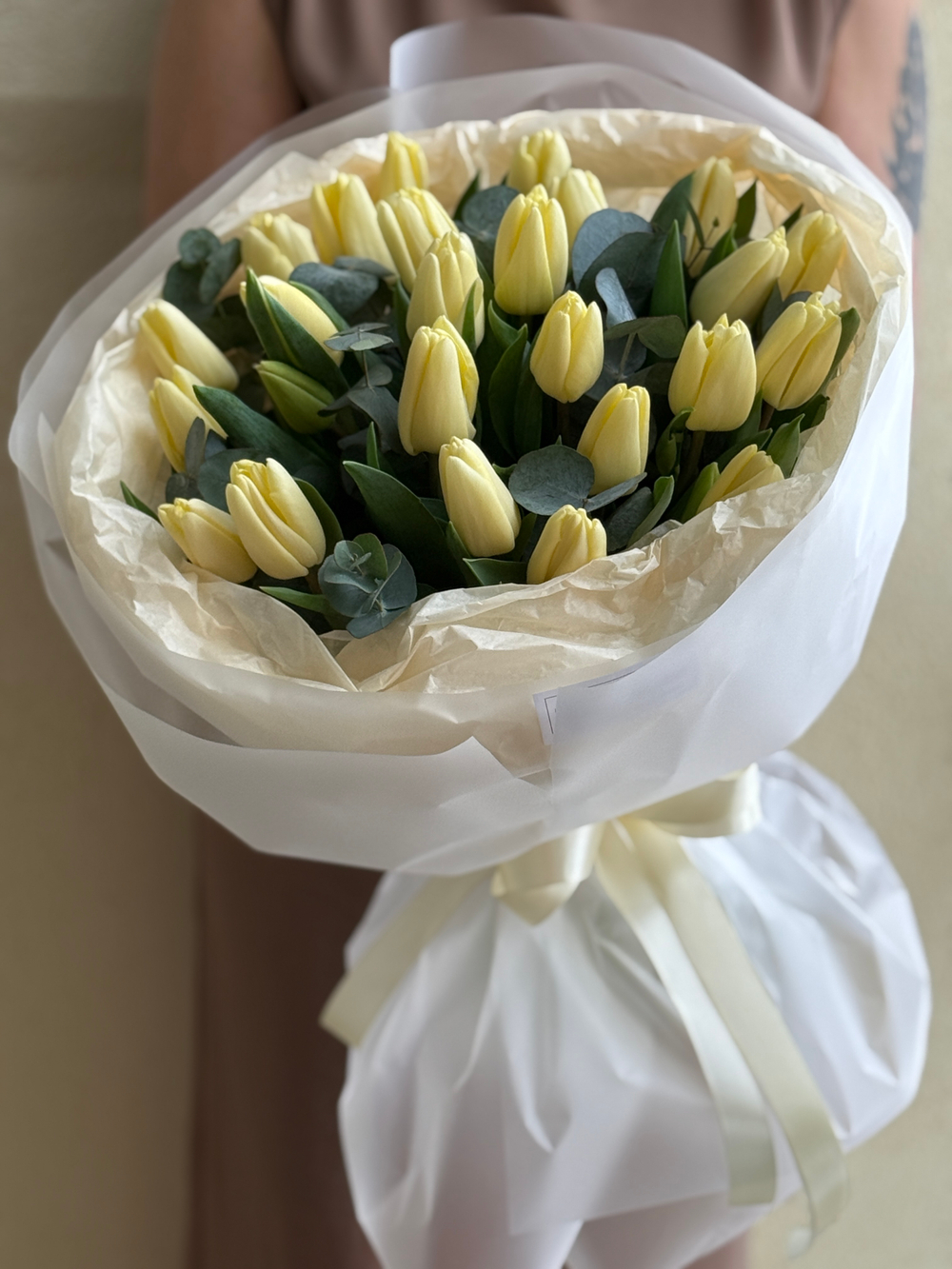 Кремовые тюльпаны и зелень эвкалипта в нежном оформлении Флора Маркет