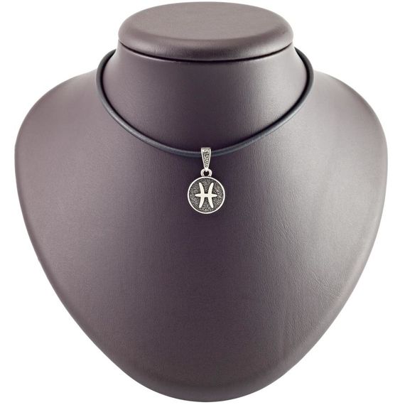 Фото знака зодиака рыбы из мельхиора на постаменте в масштабе.