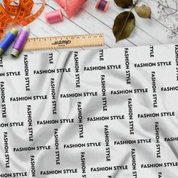 Ткань штапель стильная клетка из чёрных надписей на бежевом фоне