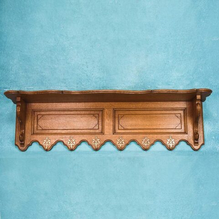 Настенная вешалка с фигурной нижней кромкой и строгой геометрией.