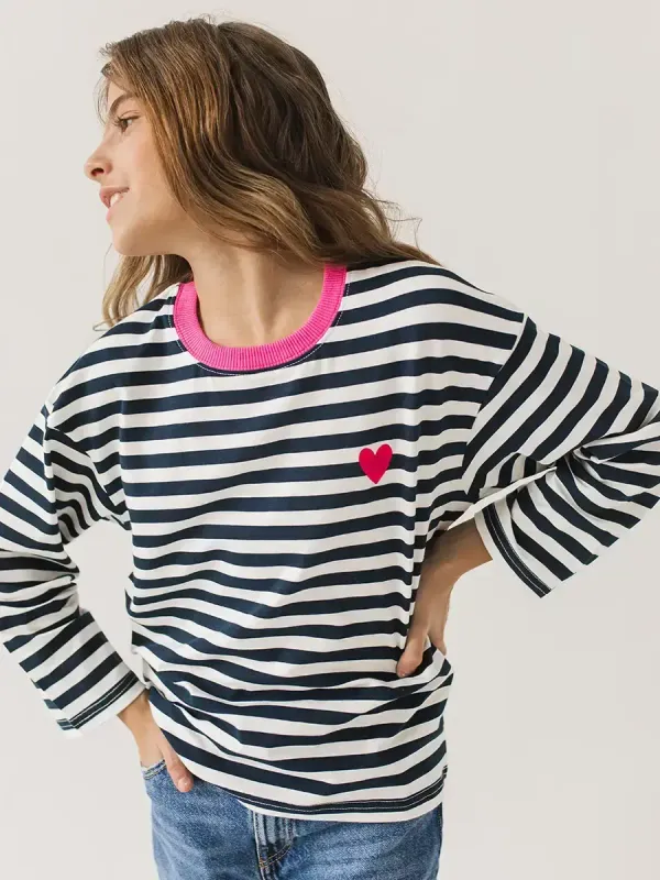 Крупный план вышивки сердца и горловины фуксия на лонгсливе в морскую полоску