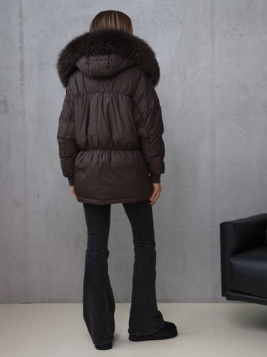 Коричневый пуховик с отделкой из меха енота