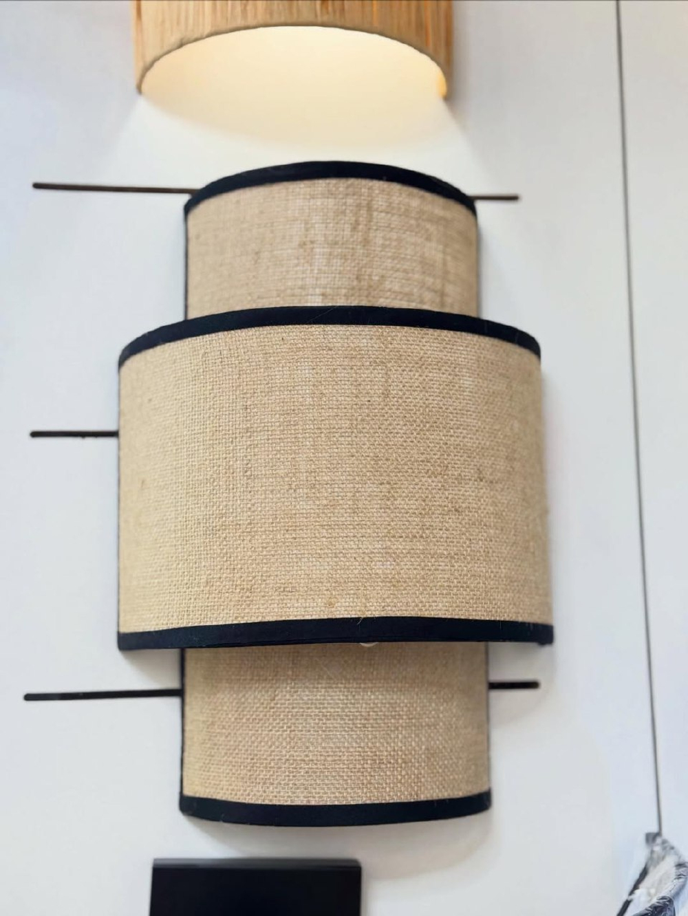 Стильное настенное бра с многоуровневым абажуром из натурального текстиля.