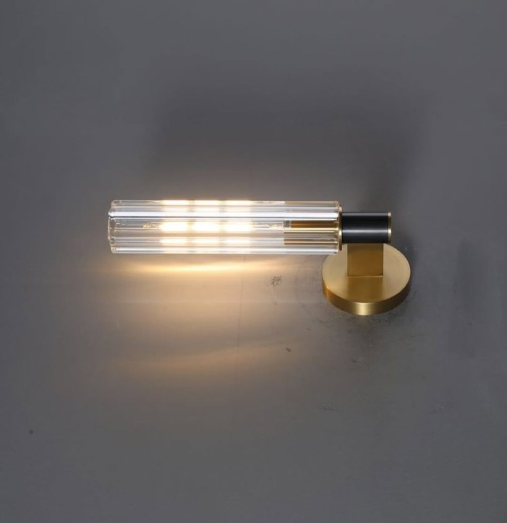 Элегантное настенное бра с вытянутым хрустальным плафоном и металлическим корпусом в тёплом золотом оттенке.