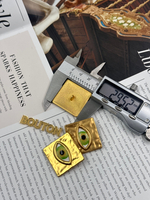 Пуговицы Скиап. золотистые квадратные с объемным желто-зеленым глазом