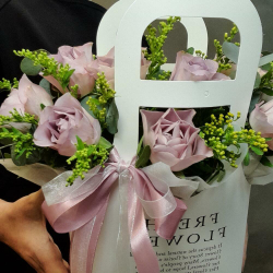 Композиция из сиреневых роз в сумочке