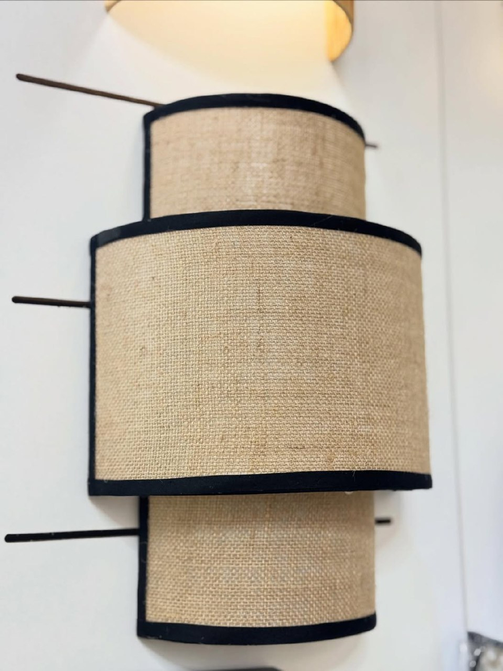 Стильное настенное бра с многоуровневым абажуром из натурального текстиля.