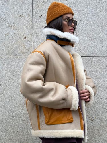 Бежевая дубленка-авиатор с контрастной отделкой