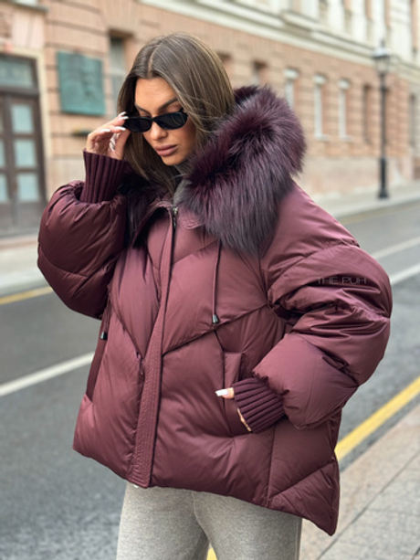 Бордовый пуховик с удлиненной спинкой и мехом енота