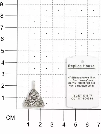 Фото серебряного оберега Триглав, вид на размерной сетке.