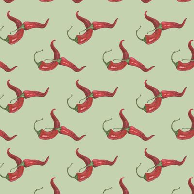 Острый красный чили перец на зеленом фоне