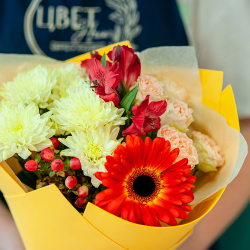Яркий букет в желтой цветовой гамме с герберами и красными розами