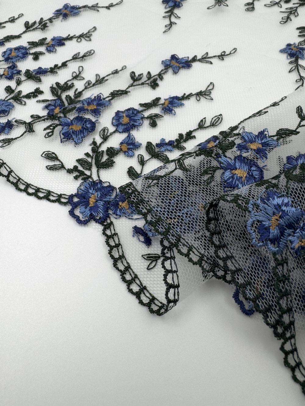 Вышивка на сетке молочная с васильковым и темно-зеленым ширина 23.5 см