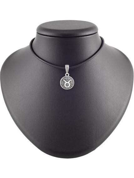 Изображение символа Телец из серебра на коричневом постаменте в масштабе.