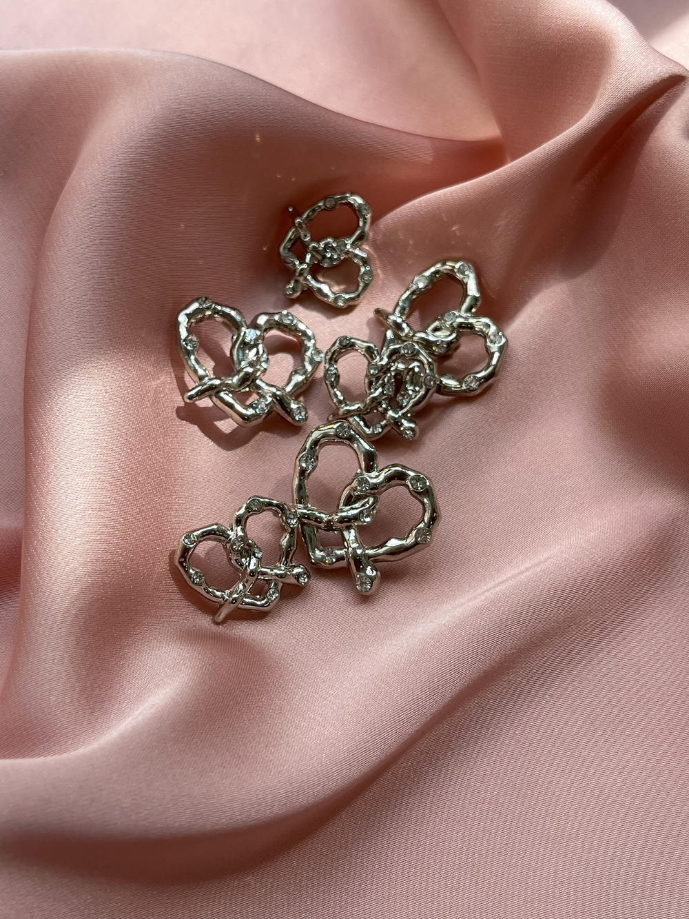 Пуговицы серебристые крендельки-сердечки со стразами