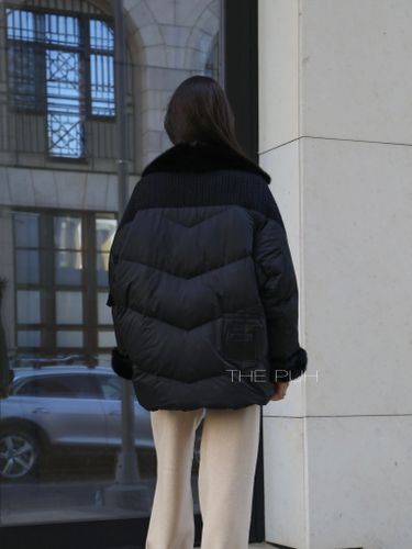 Черный пуховик с вязаными вставками и отделкой из меха